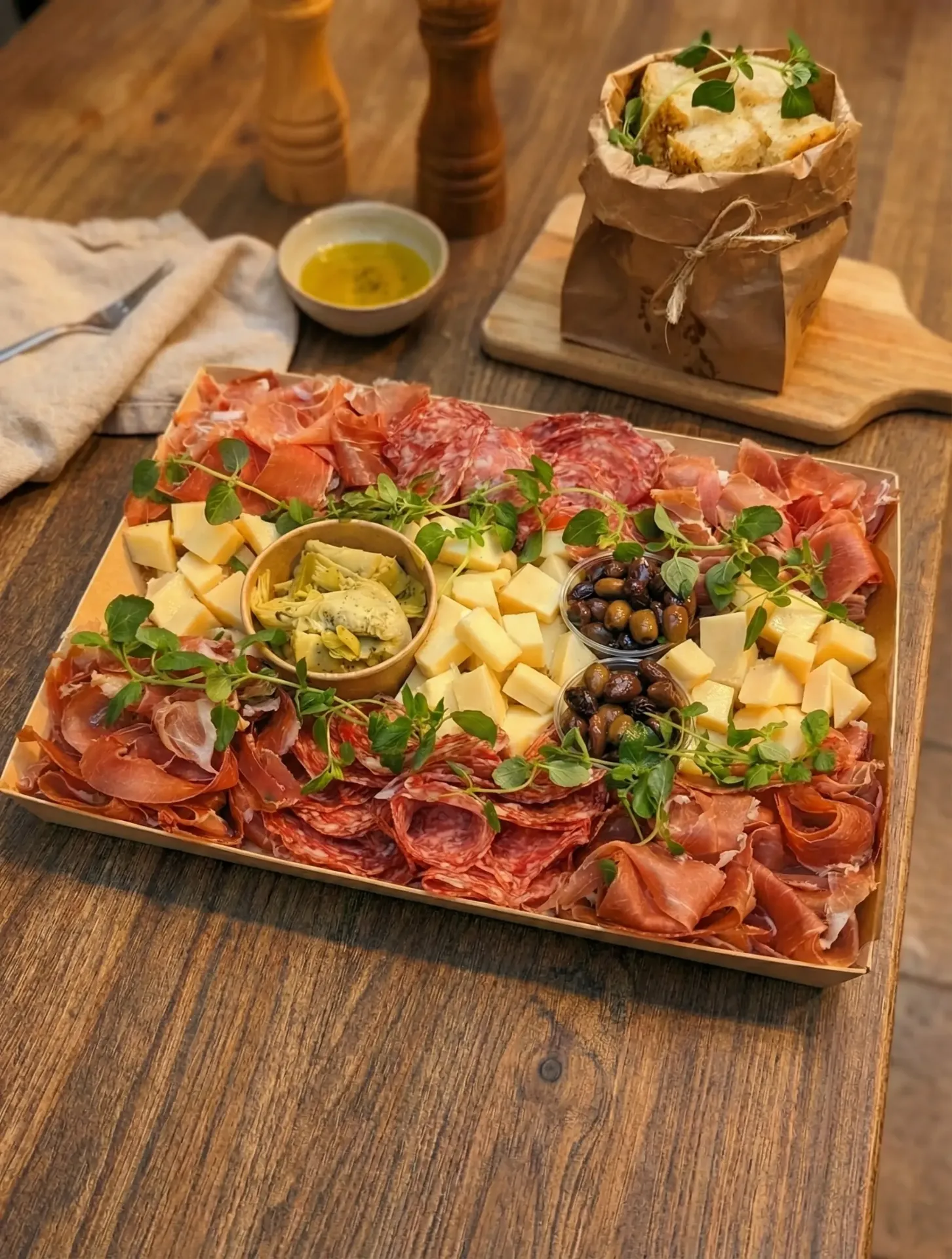 Italiensk charkbricka med prosciutto, salami, ost och oliver för kontorsmingel